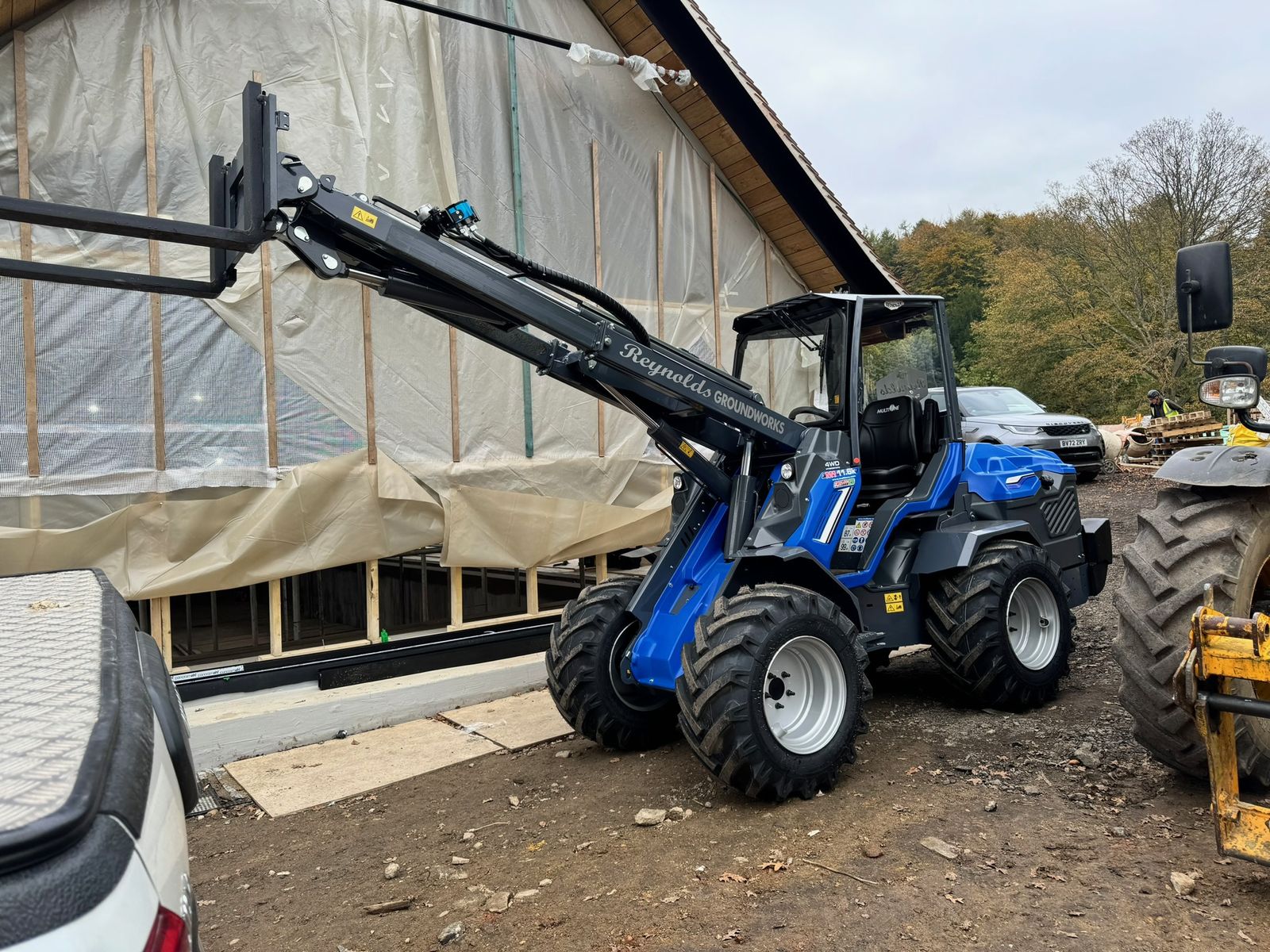 Loader working alongside an agricultural polytunnel