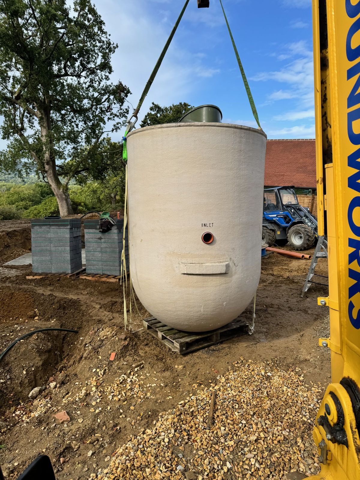 Sewage treatment tank being craned into position by a Reynolds excavator