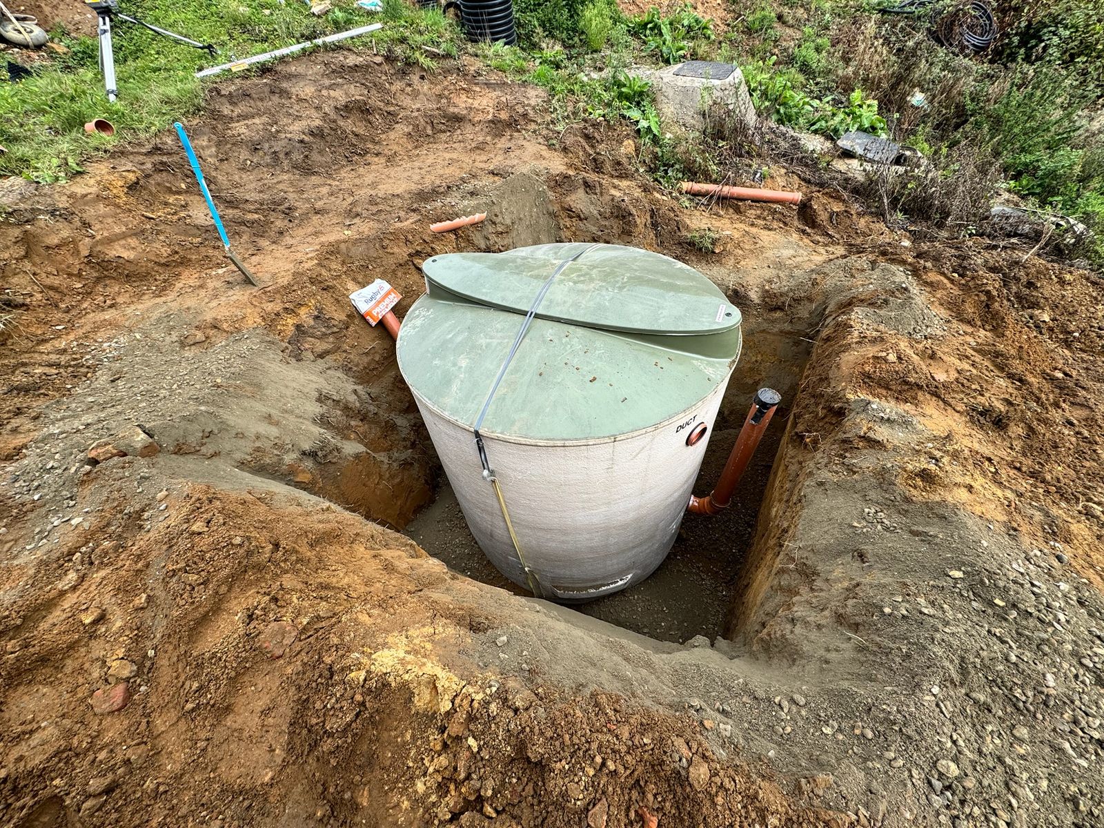 Off-mains sewage treatment tank installed in its excavation