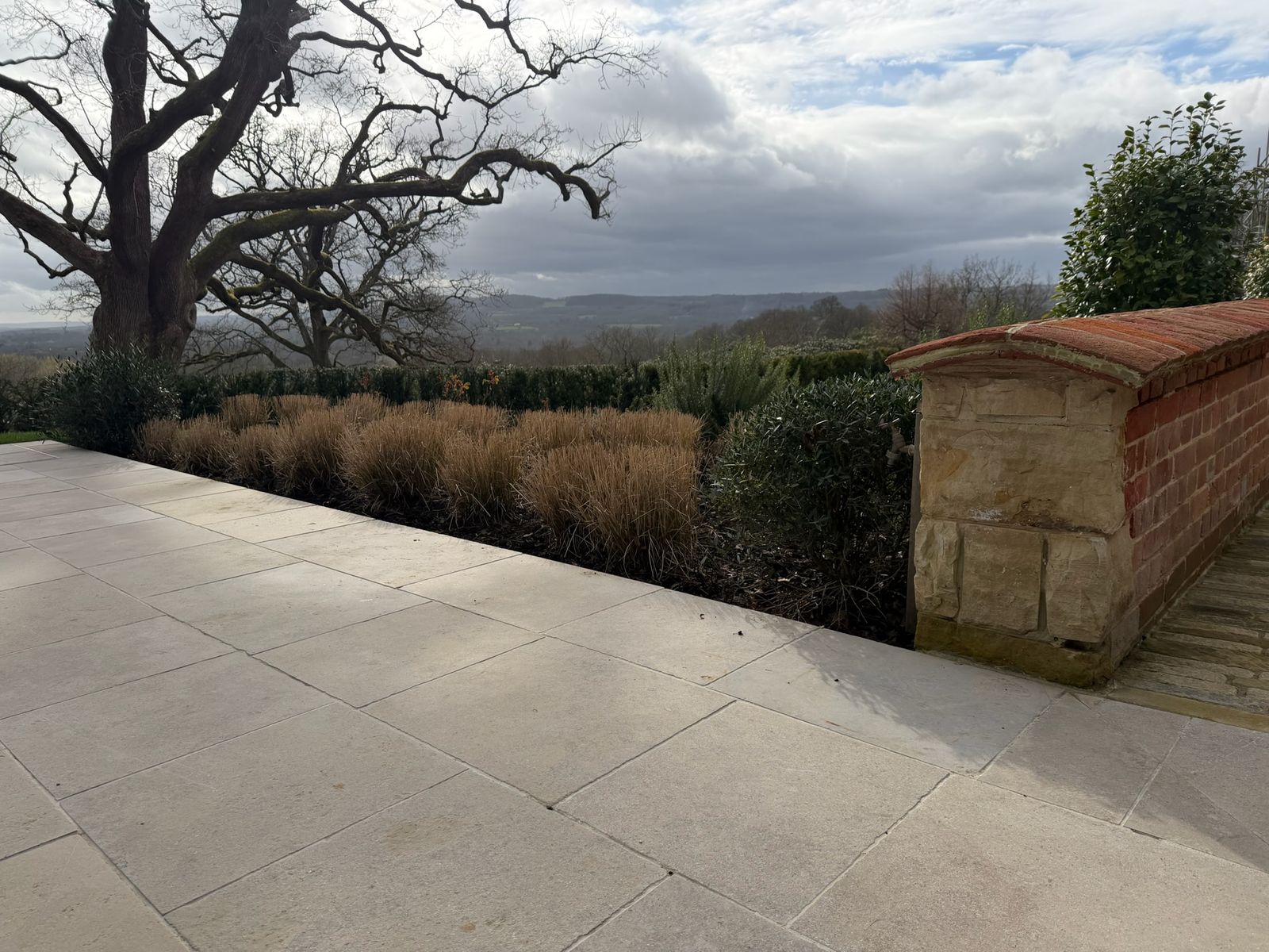 Clipped hedging and stone terrace with views across the countryside