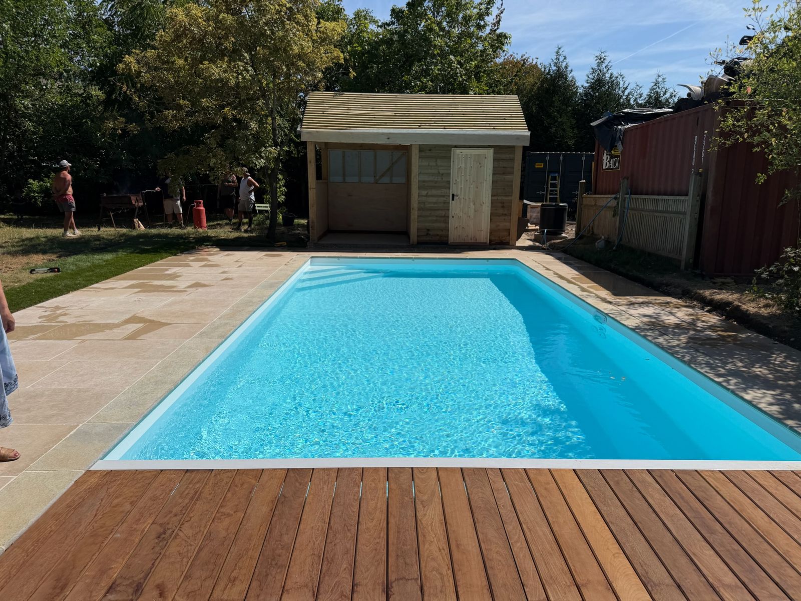Swimming pool with hardwood decking and timber garden building